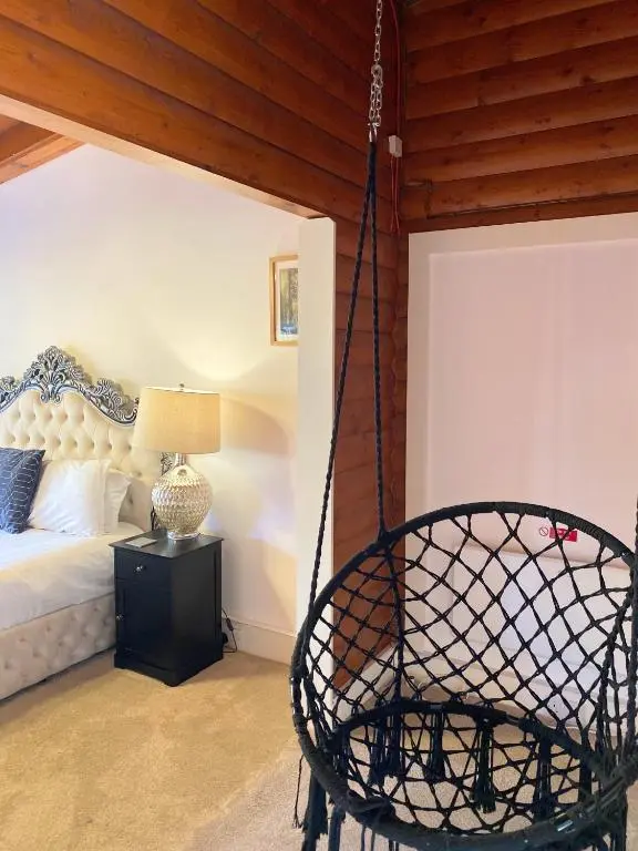a bedroom with a bed and a swing at Kaoglen-Spruce-Hot Tub-Forrest Setting-Pet Friendly in Balnald