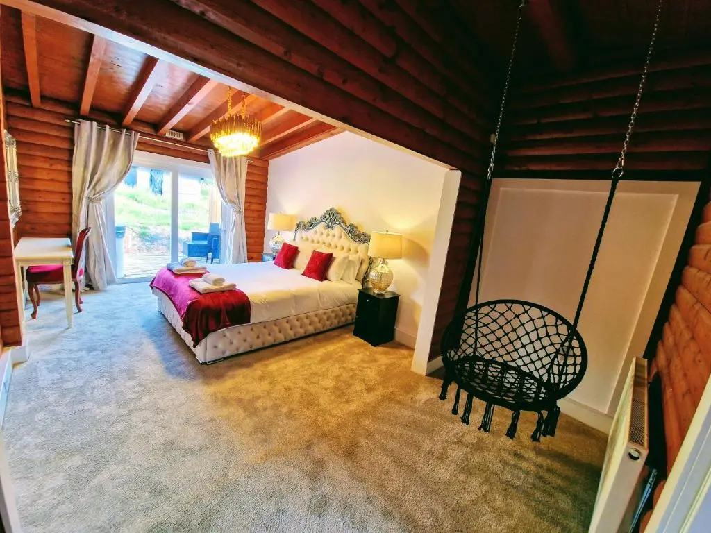 a bedroom with a bed and a chair in a room at Kaoglen-Spruce-Hot Tub-Forrest Setting-Pet Friendly in Balnald