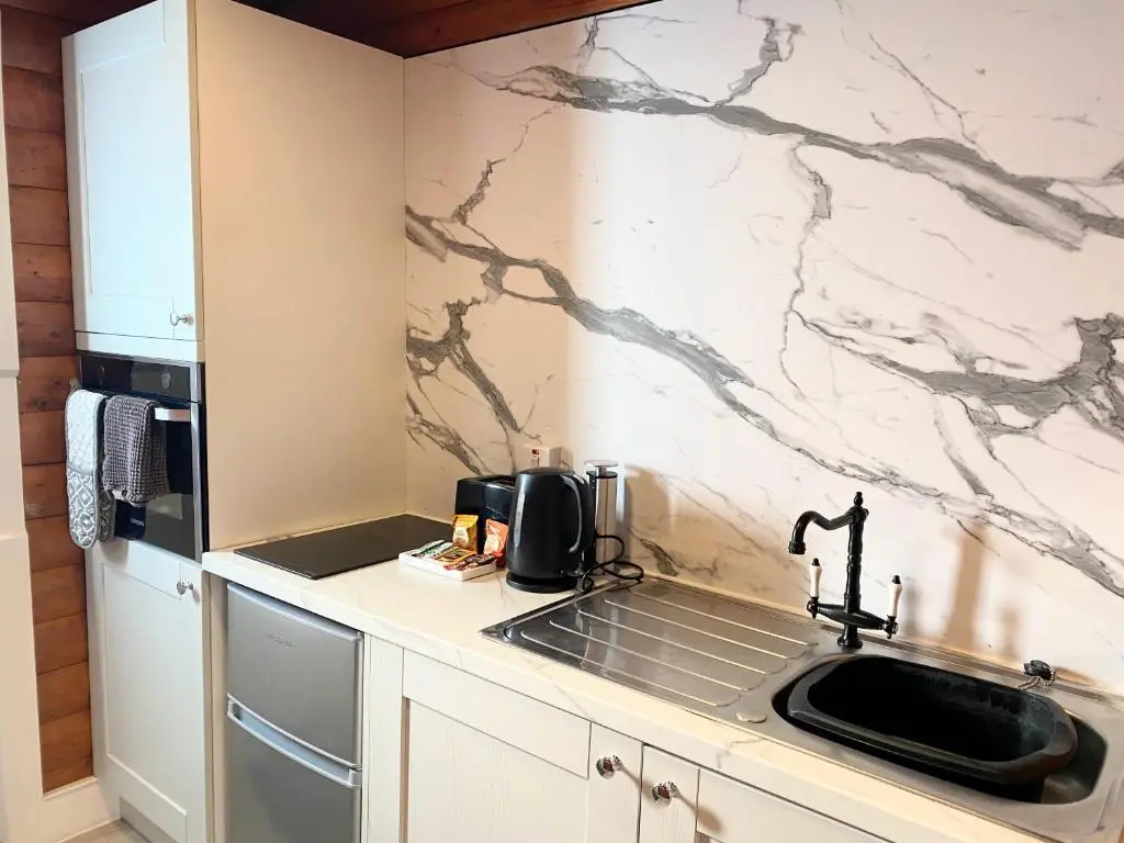 a kitchen with a sink and a counter top at Kaoglen-Spruce-Hot Tub-Forrest Setting-Pet Friendly in Balnald