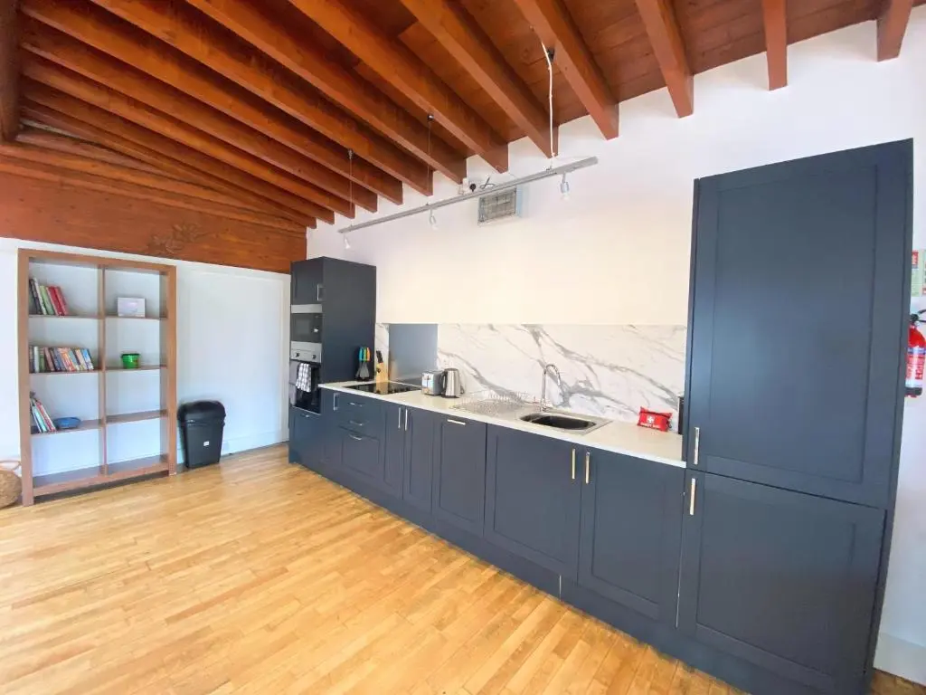 a kitchen with black cabinets and a wooden floor at Kaoglen-GrandSuite-Hot Tub-Pitlochry-Dunkeld-Pet Friendly in Balnald