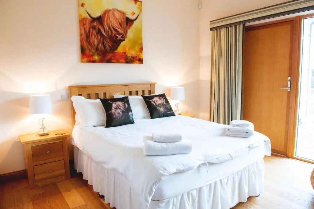 a bedroom with a bed with towels on it at Clovenstone Lodges in Inverurie