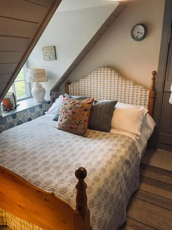 a bedroom with a bed with pillows on it at Quirky Highland Cottage with Stunning Views in Wester Fearn