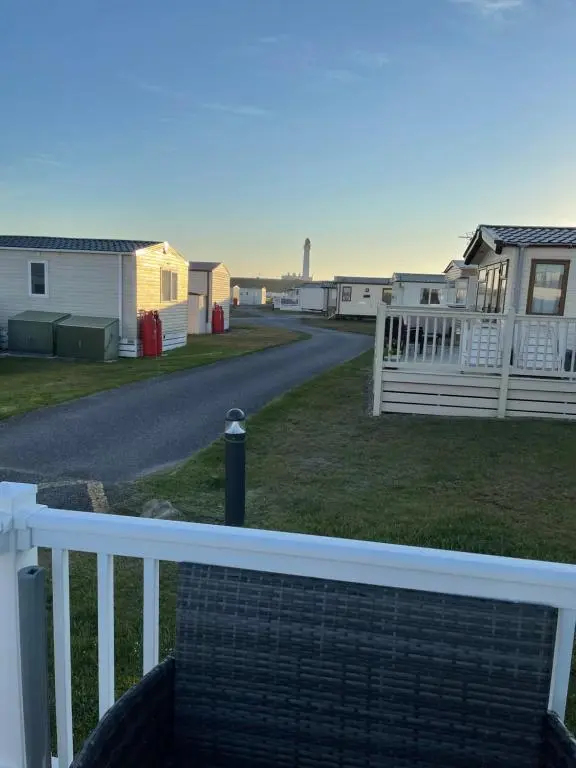 a view of a road with houses and a fence at Dune View Caravan in Lossiemouth