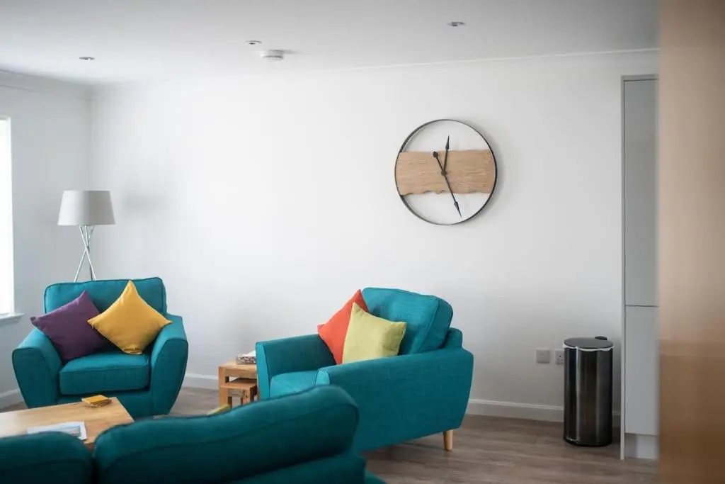 a living room with two chairs and a table at Modern Ground Floor Apartment in Tornagrain in Inverness
