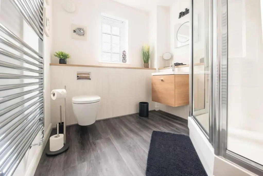 a small bathroom with a toilet and a sink at Modern Ground Floor Apartment in Tornagrain in Inverness