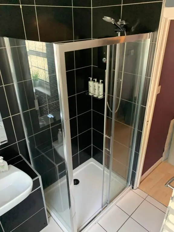 a shower with a glass door in a bathroom at Stylish apartment in the heart of Inverness in Inverness