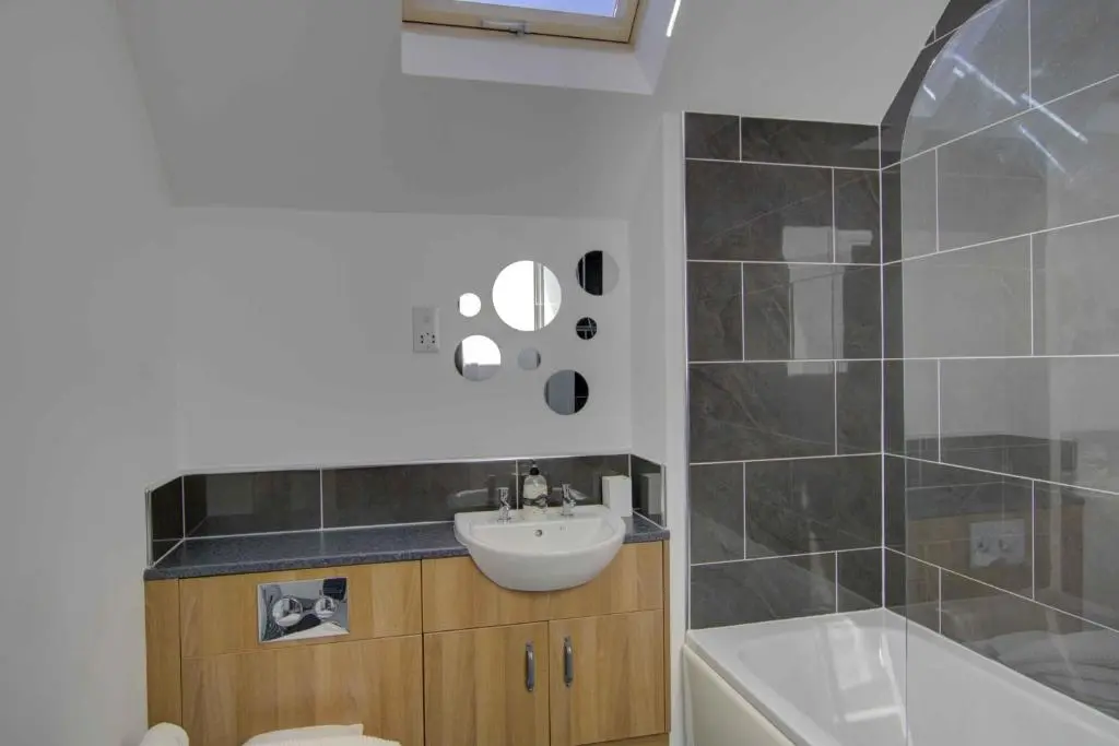 a bathroom with a sink and a toilet and a tub at 3 Mackay Road, Dornoch in Dornoch