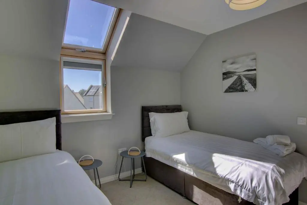 two beds in a small room with a window at 3 Mackay Road, Dornoch in Dornoch