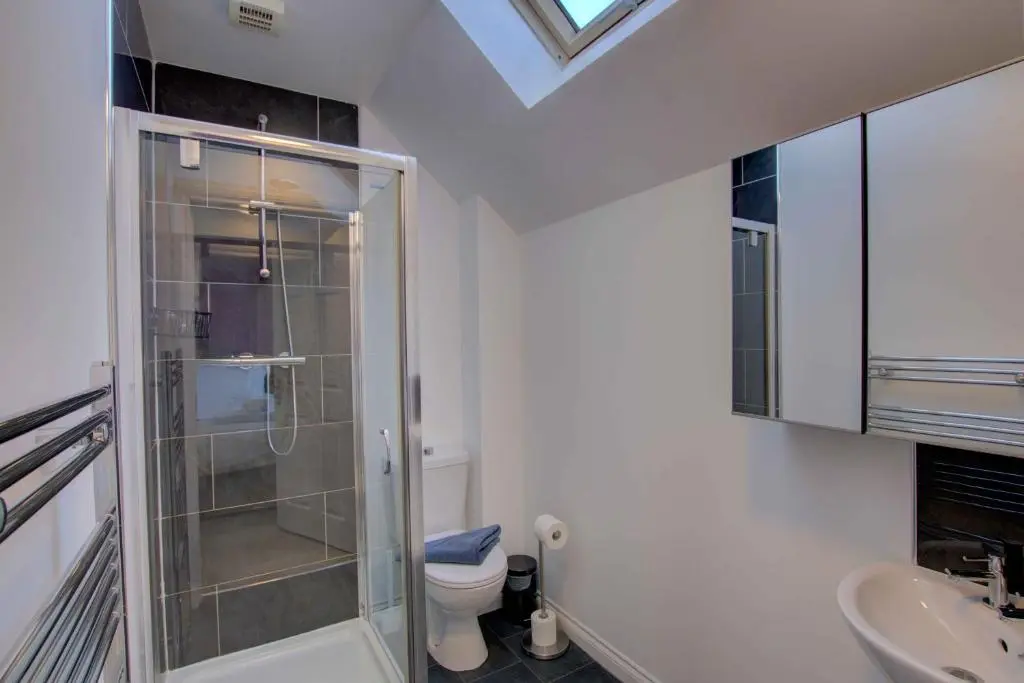 a bathroom with a shower and a toilet and a sink at 3 Mackay Road, Dornoch in Dornoch