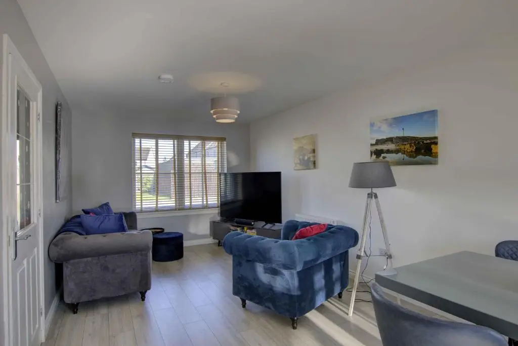 a living room with two chairs and a television at 3 Mackay Road, Dornoch in Dornoch