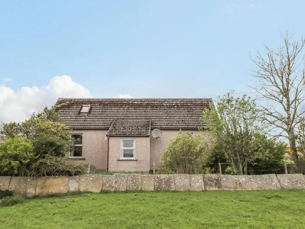 a house with a stone fence in front of it at Star Croft in Wick