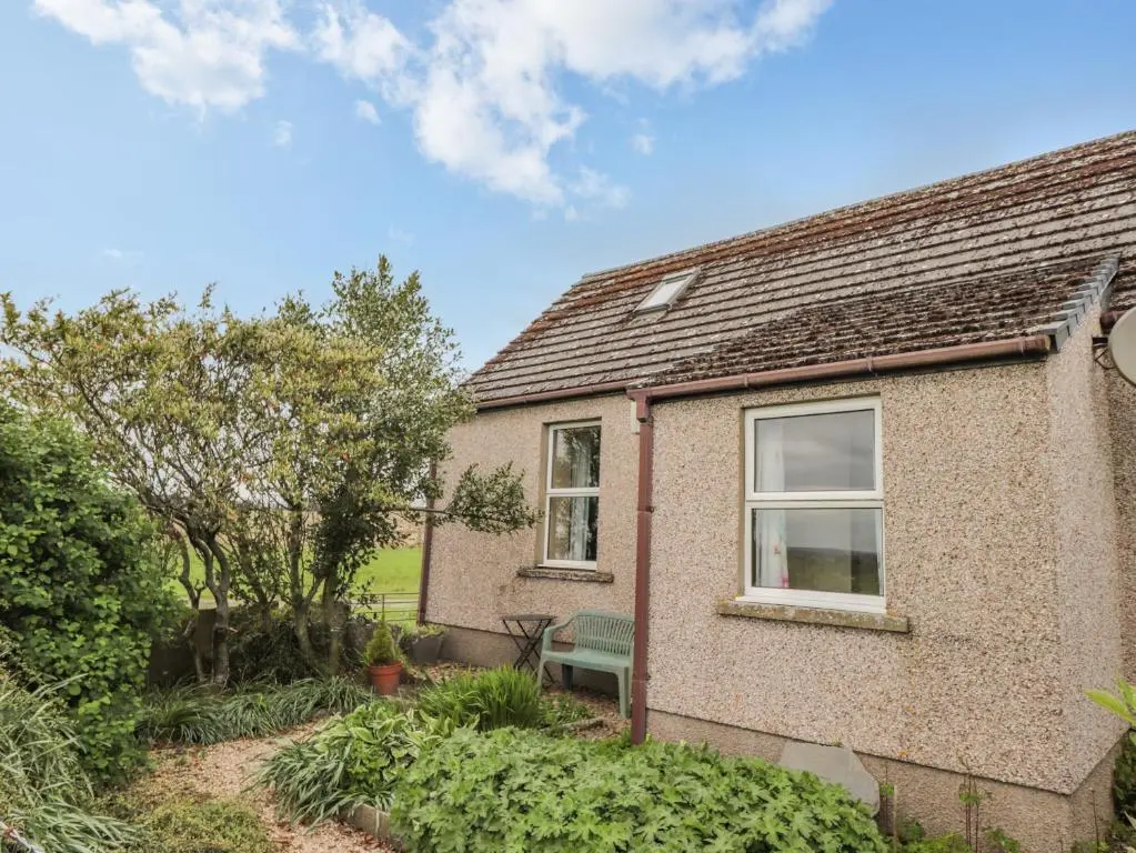 a brick house with a window and a bench at Star Croft in Wick