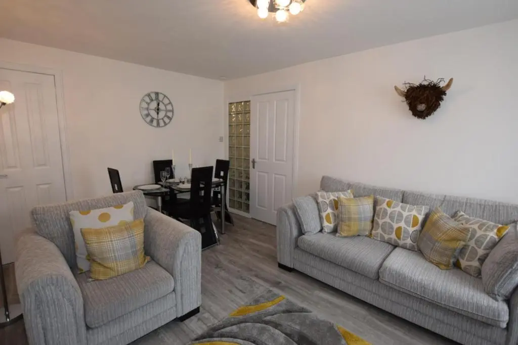 a living room with two couches and a table at Silver Key Apartments III in Inverness