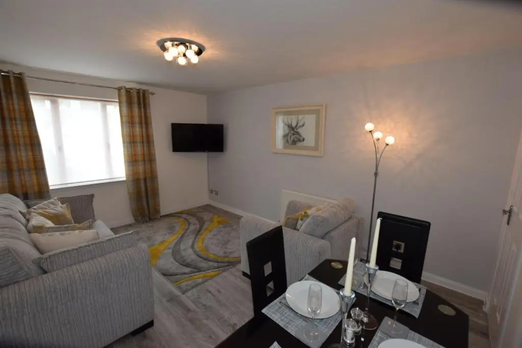a living room with two couches and a tv at Silver Key Apartments III in Inverness