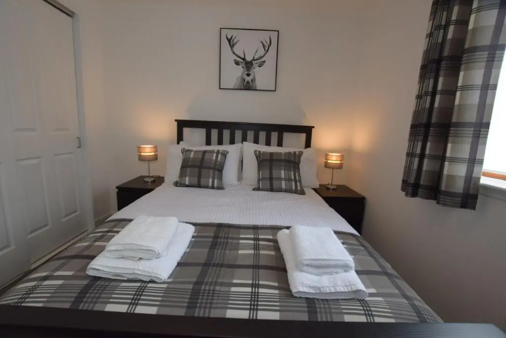a bedroom with a bed with towels on it at Silver Key Apartments III in Inverness