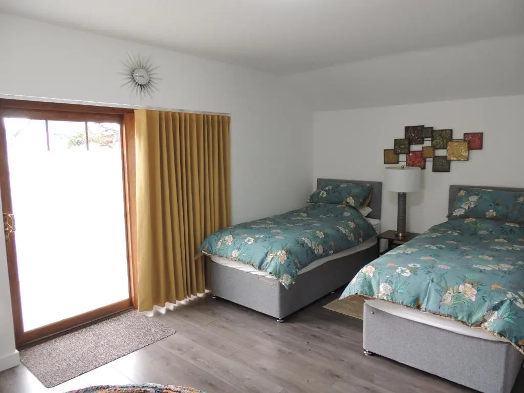 a bedroom with two beds and a window at Braeview Studio in Macduff