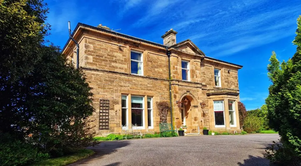 an old stone house on a road at The Pines Guest House in Elgin