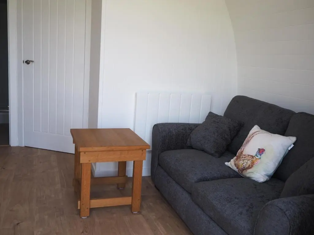 a living room with a couch and a table at Ptarmigan in Nethy Bridge