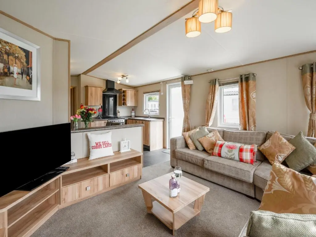 a living room with a couch and a tv at Holiday Home Golf View by Interhome in Nairn