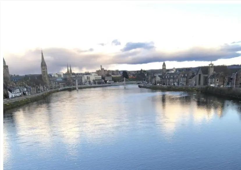 a view of a river with a city in the background at The Castle Front Nest in Inverness