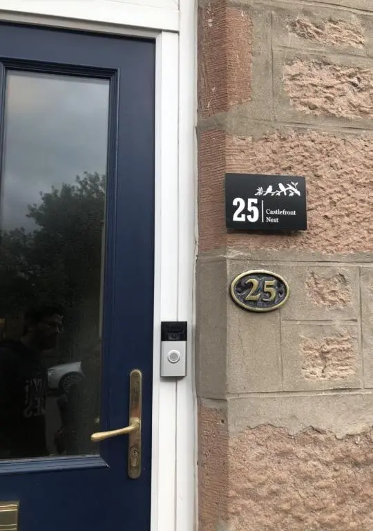 a door of a building with a sign next to it at The Castle Front Nest in Inverness