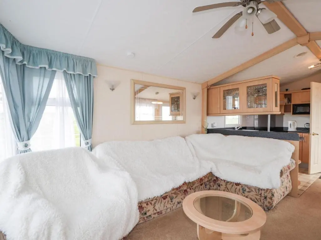 a living room with a couch and a ceiling fan at The Cabin in Lybster