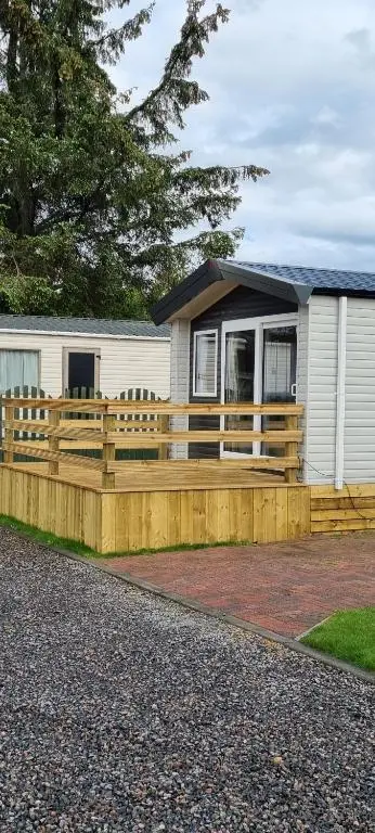 a house with a wooden fence in front of it at The Wee Hoose in Boat of Garten