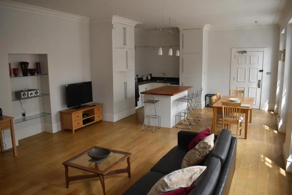 a living room with a couch and a table and a kitchen at Central 1-Bed Apartment in Inverness Sleeps 4 in Inverness