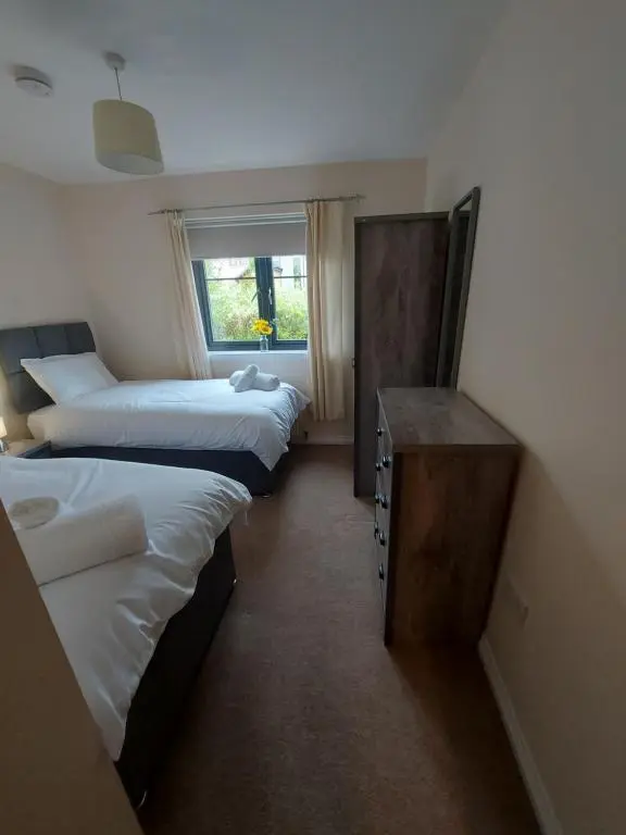 a room with three beds and a window at The Mews in Inverness