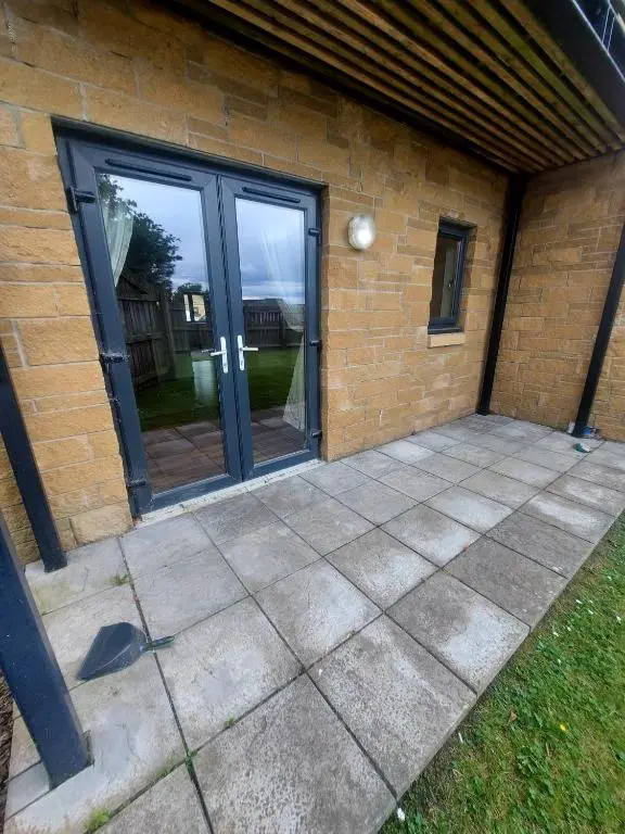 a patio with sliding glass doors on a brick building at The Mews in Inverness
