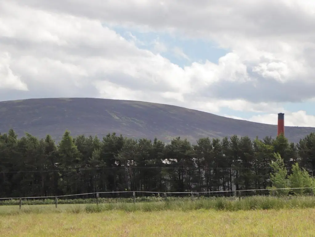 a fence in a field with a mountain in the background at Moss of Bourach in Aberlour