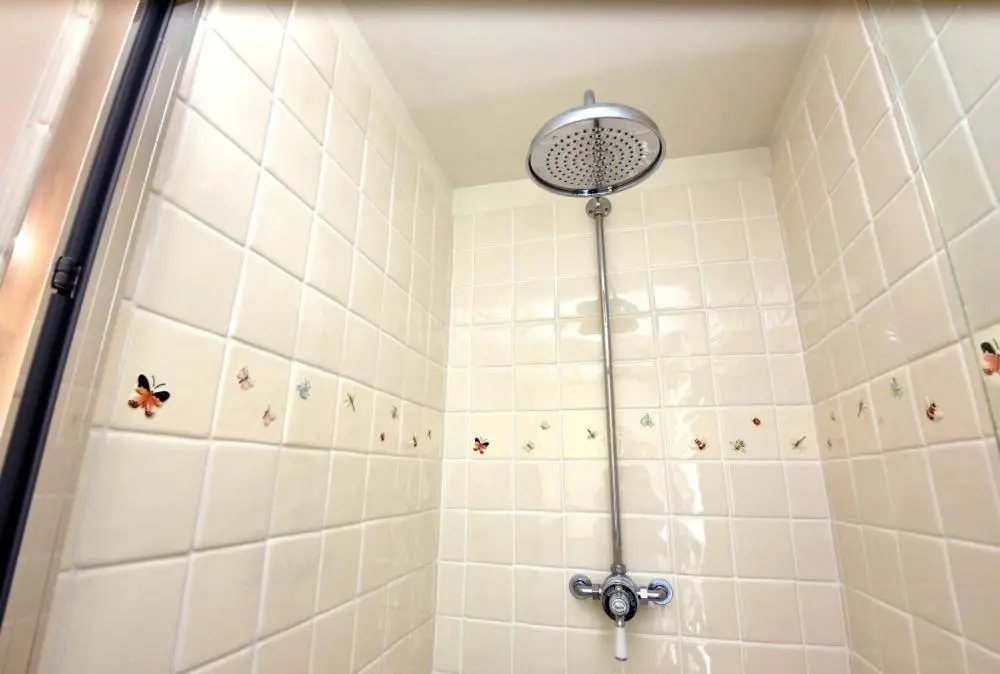 a shower with a shower head in a bathroom at Gardener's Cottage in Elgin