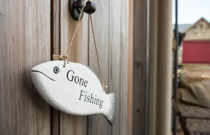 a white fish hanging on a door with the words gone fishing at Clashindeugle Farmhouse & Annex in Grantown on Spey