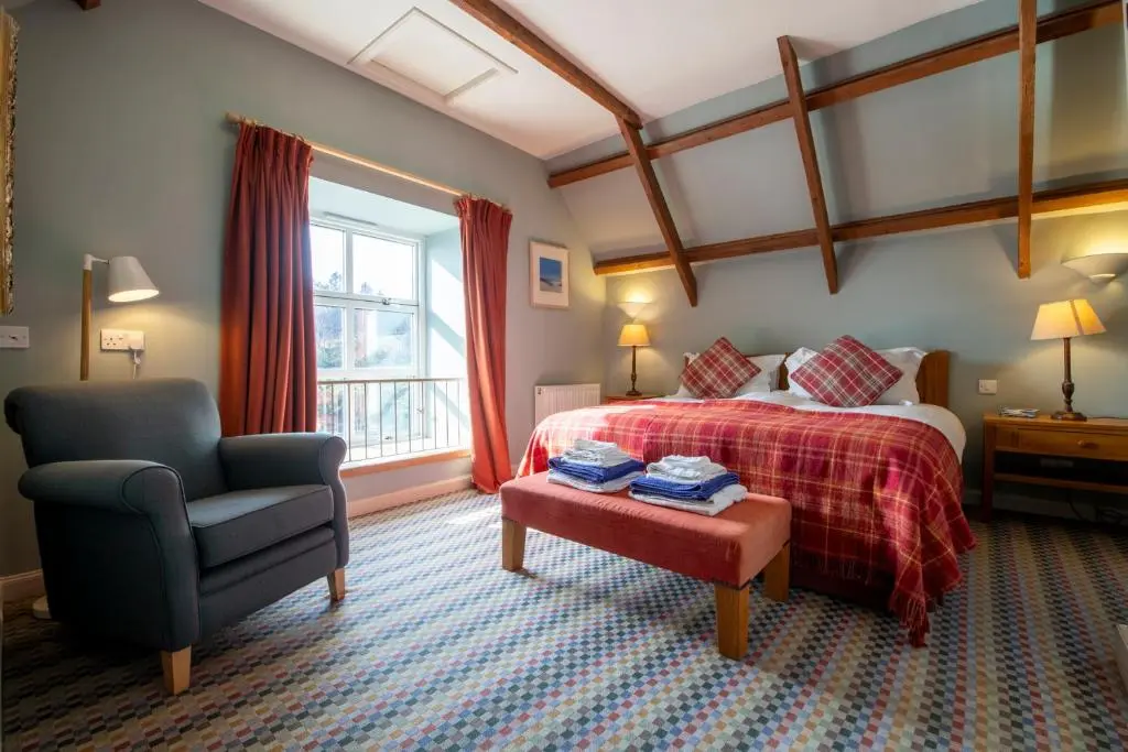 a hotel room with a bed and a chair at Quarryfield in Inverness