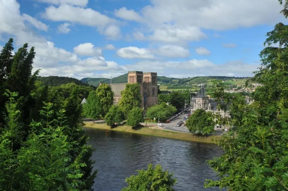 a river in front of a city with a castle at Inverness City Apartment in Inverness