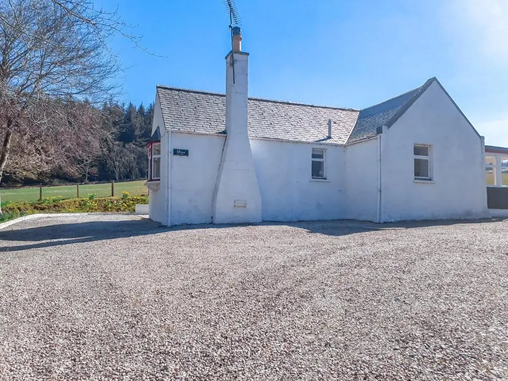 a white church with a tower on a gravel driveway at Ivy Cottage in Mountblairy