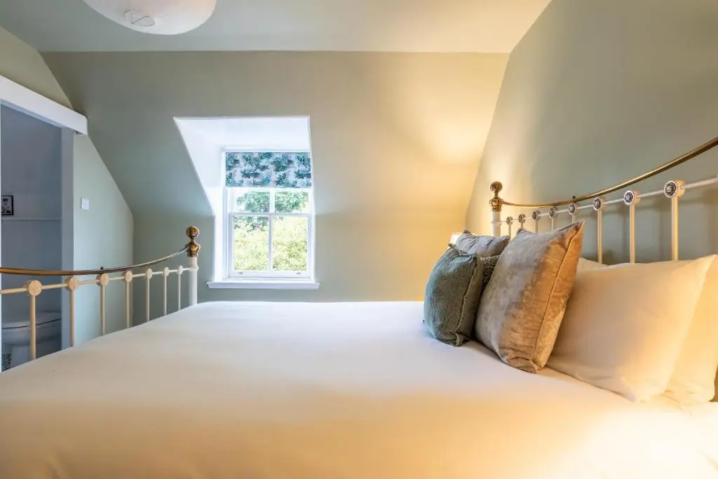 a bedroom with a bed with pillows at Ness on the Lane in Inverness