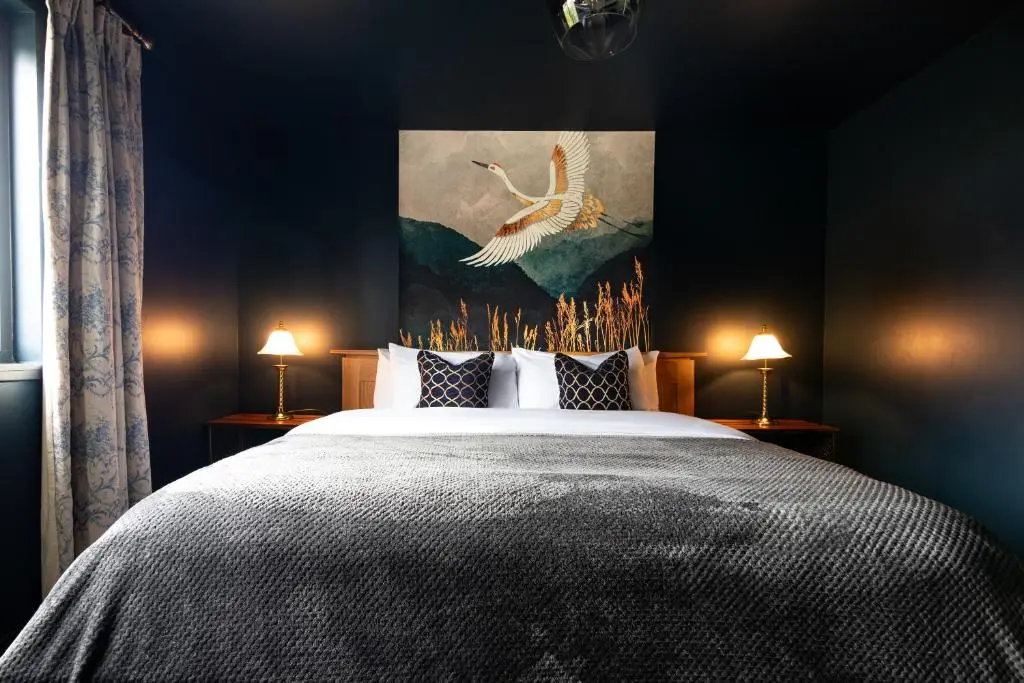 a bedroom with a large bed with a painting on the wall at Ness on the Lane in Inverness