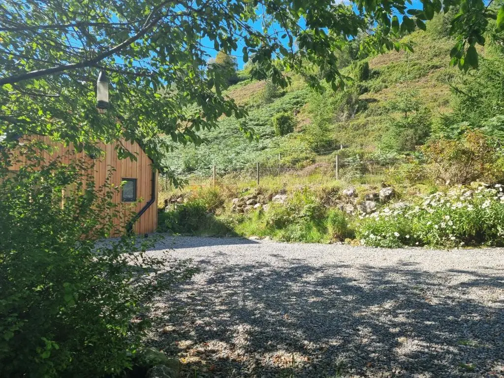 a gravel road leading to a building with a mountain at Cozy Nook in Spean Bridge
