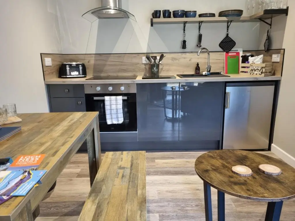 a kitchen with a counter and a table and a sink at Cozy Nook in Spean Bridge