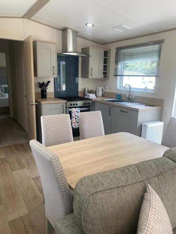a kitchen with a wooden table and chairs in a kitchen at Feorag Lodge in Aviemore