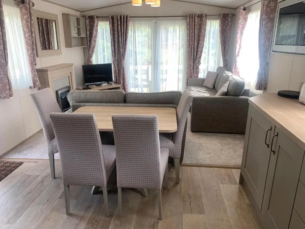 a kitchen and living room with a table and chairs at Feorag Lodge in Aviemore