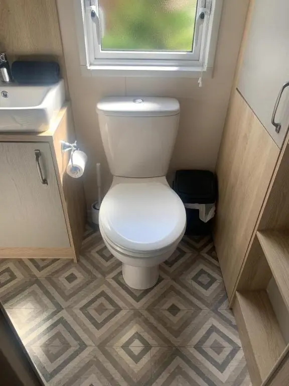 a small bathroom with a toilet and a window at Feorag Lodge in Aviemore