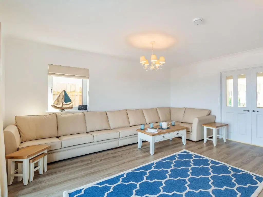 a living room with a couch and a table at Headland View in Banff