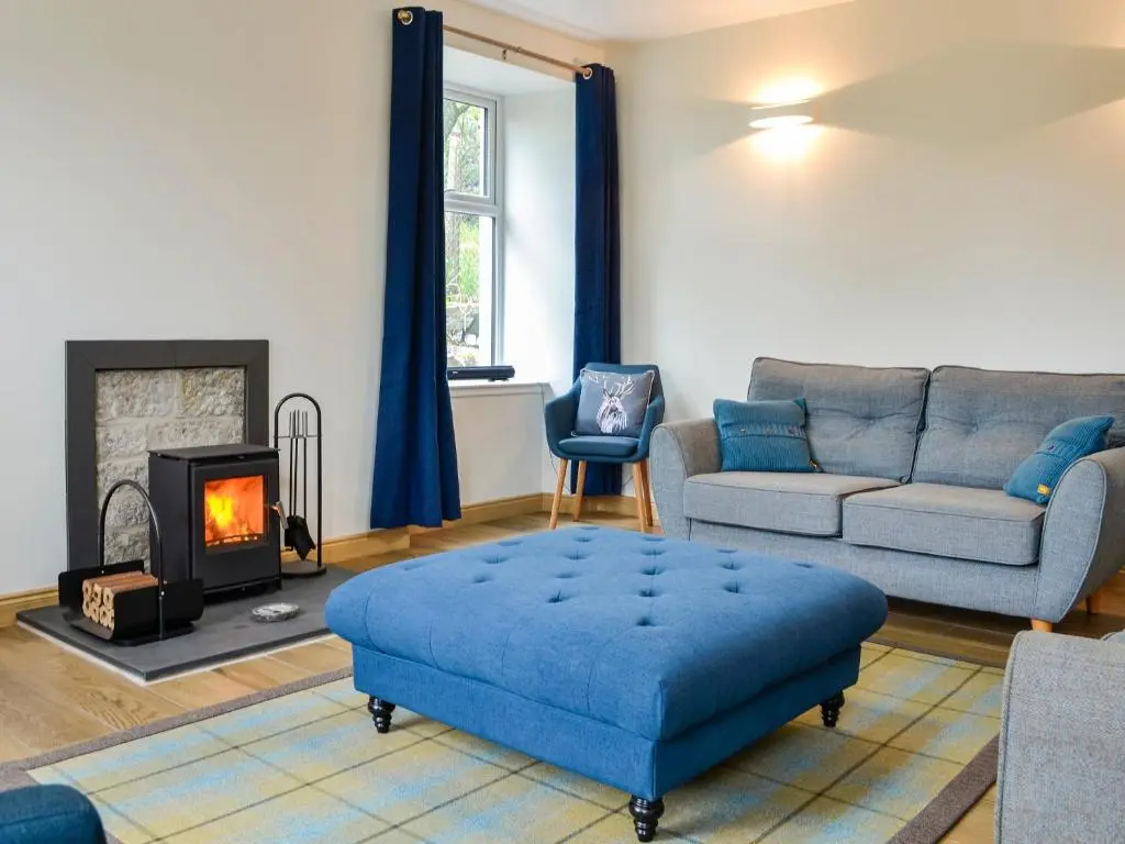 a living room with a couch and a fire place at Druids Knowe in Tarfside
