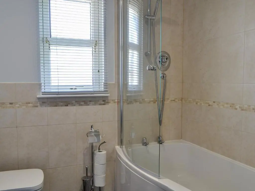 a bathroom with a shower and a tub and a toilet at Queen's View Lodge in Inchmarlo