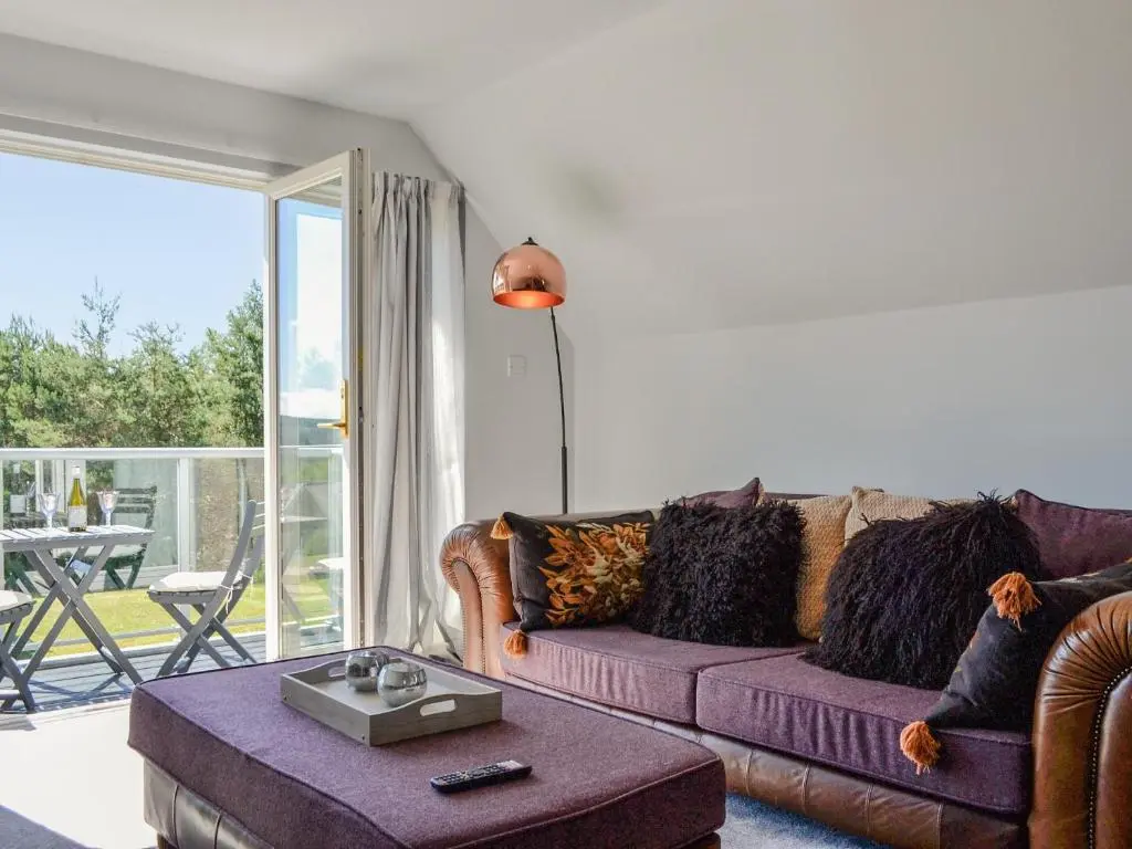 a living room with a couch and a table at Queen's View Lodge in Inchmarlo