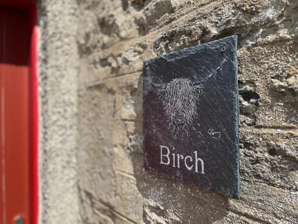 a sign on the side of a stone building with a british sign on at Birch Cottage - Uk38992 in Dalcross