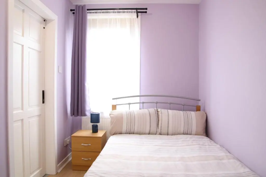 a bedroom with a bed with a window and a nightstand at Aria Lodging Inverness in Inverness