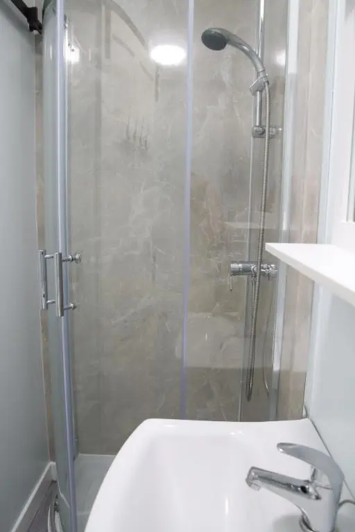 a bathroom with a shower with a sink and a toilet at Aria Lodging Inverness in Inverness